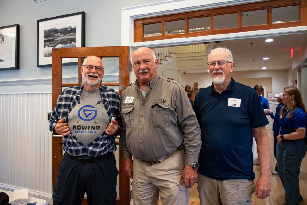 Man shows his row t-shirt off with his friends